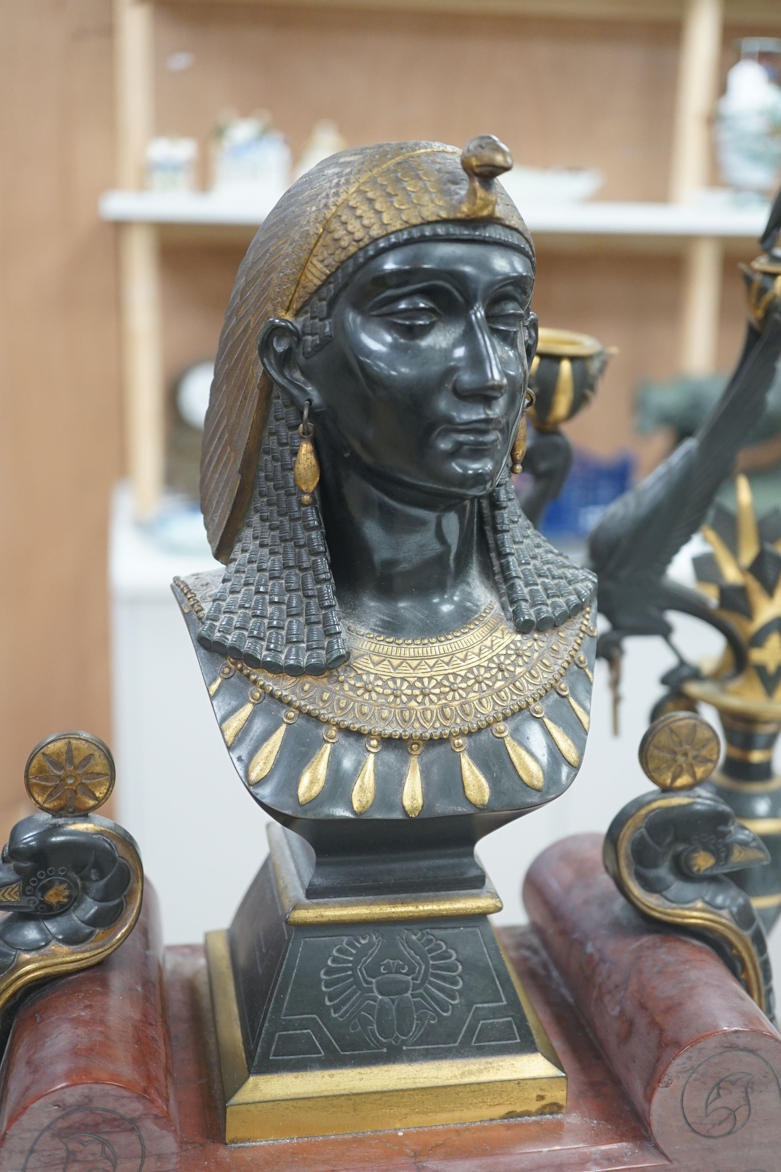 A late 19th century French Egyptian Revival gilt bronze and rouge marble clock garniture, 51cm